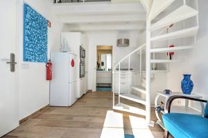 uma cozinha com um frigorífico branco e um sofá azul em Blue Barqueta Studio em Faro
