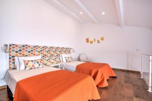 a bedroom with two beds and an orange blanket at Terrace Barqueta Studio in Faro