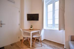 mały stół i krzesła w pokoju z oknem w obiekcie Yellow Barqueta Studio w Faro