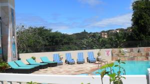 uma fila de cadeiras azuis sentadas ao lado de uma piscina em Uvongo River Resort em Margate