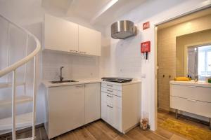 a kitchen with white cabinets and a staircase at Yellow Barqueta Studio in Faro