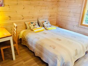 Cama grande en habitación de madera con mesa en Villa by the Lake, en Joutseno