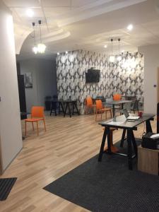 Cette chambre dispose de tables, de chaises et d'un mur avec une télévision. dans l'établissement Hostel City Center Gdynia, à Gdynia
