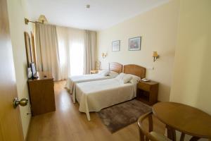 um quarto de hotel com uma cama, uma mesa e uma mesa em A Vileira em Vimioso