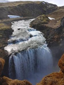 a waterfall in the middle of a mountain at Hólaskjól Highland Center in Kirkjubæjarklaustur