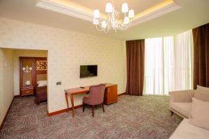 Habitación de hotel con escritorio y sala de estar. en AZPETROL HOTEL QUSAR, en Qusar