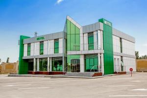 a green and white building with a parking lot at AZPETROL HOTEL QUSAR in Qusar
