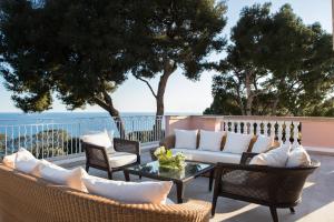 a patio with a couch and chairs and a table at Grand-Hôtel du Cap-Ferrat, A Four Seasons Hotel in Saint-Jean-Cap-Ferrat
