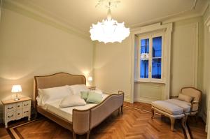 1 dormitorio con cama y lámpara de araña en VILLA PARADISO AU LAC, en Moltrasio