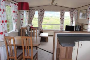 a kitchen and dining room with a table and chairs at Glen View in Taynuilt