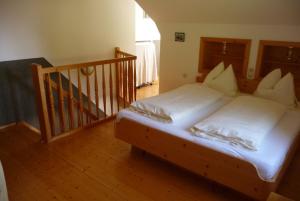 1 cama con sábanas blancas y almohadas en una habitación en Pension Ladner, en Grundlsee