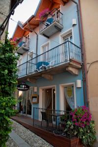 a building with balconies and tables and chairs and flowers at Hotel Bettina in Mergozzo