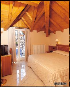 メルゴッツォにあるHotel Bettinaのベッドルーム(ベッド1台、テレビ、窓付)