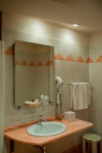 bagno con lavandino e specchio di Hotel Bettina a Mergozzo