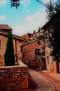 een steegje in een oud bakstenen gebouw met een boom bij Apartments Aurora Delle Rose in Assisi