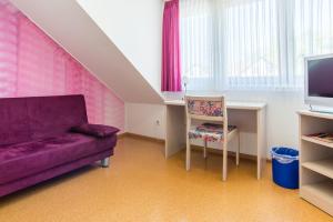 a living room with a purple couch and a chair at Gasthaus Pension Löwen in Freiburg im Breisgau