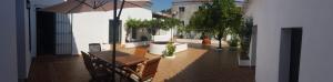 patio z drewnianym stołem i parasolem w obiekcie Sierra de Aracena Cala Huelva w mieście Cala