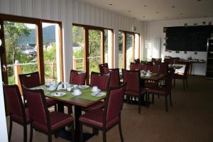 a dining room with tables and chairs and windows at Hinter den Spiegeln in Heimbach