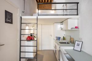 una pequeña cocina con una cama elevada en una habitación en Honorê - Suite Mercière, en Lyon