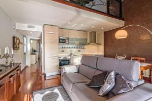 a living room with a couch and a kitchen at Apartamento con encanto en Badalona in Badalona