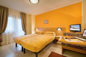 a hotel room with a bed and a desk at Garni Oasi in Livigno