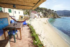 ポルトフェッラーイオにあるAppartamento il Sottomarino - Goelbaのビーチを見渡すバルコニー(テーブル、椅子付)