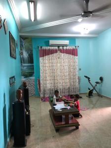 2 bambini seduti in una stanza con tavolo di Homestay Tapang a Kota Bharu