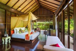 a bedroom with a bed and a couch in a room at Zeavola Resort in Phi Phi Islands