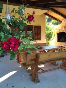 a wooden bench in front of a house with roses at Holiday home Ema in Tuheljske Toplice