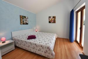 a bedroom with a bed and two pictures on the wall at Villa Kmacici 376 in Sveti Lovreč Pazenatički