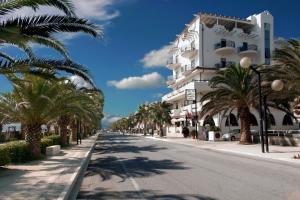 a street in front of a white building with palm trees at Sympathy Hotel in Martinsicuro