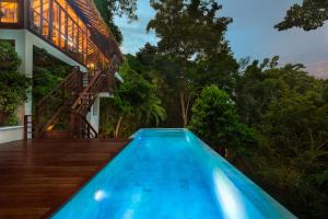 a swimming pool in front of a house with trees at Zeavola Resort in Phi Phi Islands