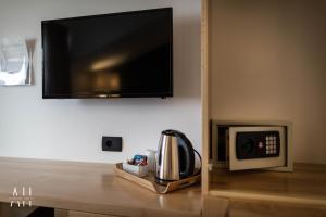 Zimmer mit einer Mikrowelle und einem TV an der Wand in der Unterkunft GARNI HOTEL ATRIUM in Nikšić