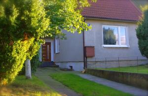 uma casa branca com um telhado vermelho em Cherry Tree Guest House em Gdansk