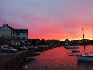a marina with boats in the water at sunset at Hôtel des Rochers in Perros-Guirec