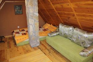 Vila Zlatibor Tornik في زلاتيبور: سريرين في غرفة ذات أرضيات وأسقف خشبية