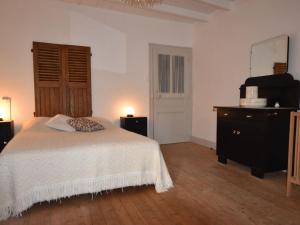 1 dormitorio con 1 cama, vestidor y TV en Spacious holiday home near the forest en Barricourt