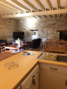 eine Küche und ein Esszimmer mit einem Tisch und Stühlen in der Unterkunft Logis de Poëllier in Baugé
