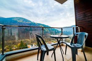 - un balcon avec deux chaises et une table avec vue dans l'établissement SinaiaMountainView - Panoramic, à Sinaia