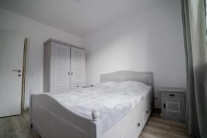 - une chambre blanche avec un lit blanc et une armoire dans l'établissement SinaiaMountainView - Panoramic, à Sinaia