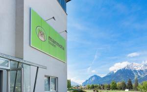 a green building with a clock on the side of it at Hostel Marmota in Innsbruck