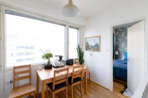 a kitchen and dining room with a table and chairs at Stay Here Apartment Kamppi in Helsinki