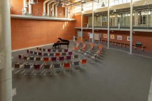 een vleugel in een grote kamer met stoelen bij Wilhelm-Kempf-Haus in Wiesbaden