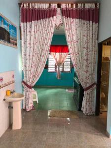 bagno con lavandino e finestra con tende di Homestay Tapang a Kota Bharu