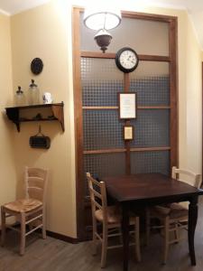a dining room with a table and a clock on the wall at Cappone B&B in Morciano di Romagna +13 photos