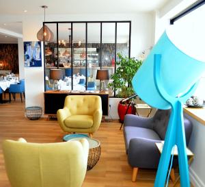 una sala de espera con sillas, una mesa y una planta en Le Galion Hotel et Restaurant Canet Plage - Logis en Canet-en-Roussillon