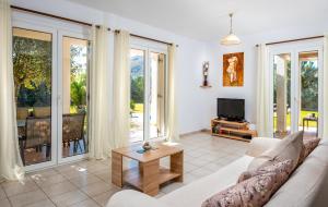 Una sala de estar con un sofá y un televisor. en Afrodite Classico Villa, en Kolymbia