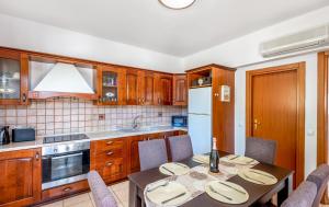 Una cocina con gabinetes de madera y una mesa con sillas. en Afrodite Classico Villa, en Kolymbia