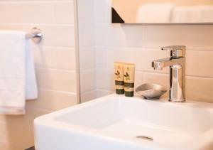 W łazience znajduje się biała umywalka i lustro. w obiekcie Giardinetto w mieście Pettenasco