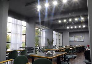 a dining room with tables and chairs and windows at Apart Hotel Alvear in Rosario